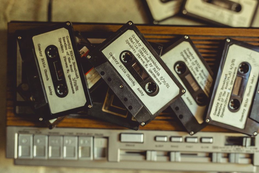 cassette tapes and field recorder on a wooden surface