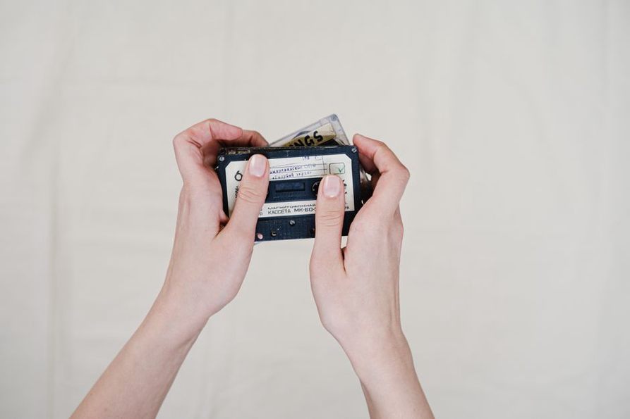 hand holding a cassette with a handwritten insert
