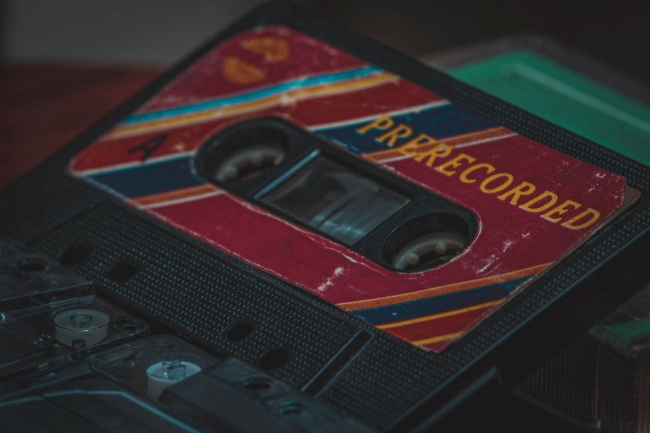 Cassette tape with faded handwritten label and exposed magnetic tape