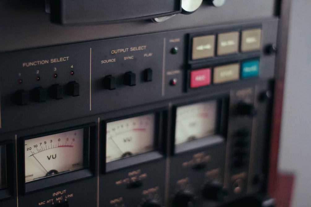 Front panel of a four-track cassette recorder, faded plastic and worn buttons