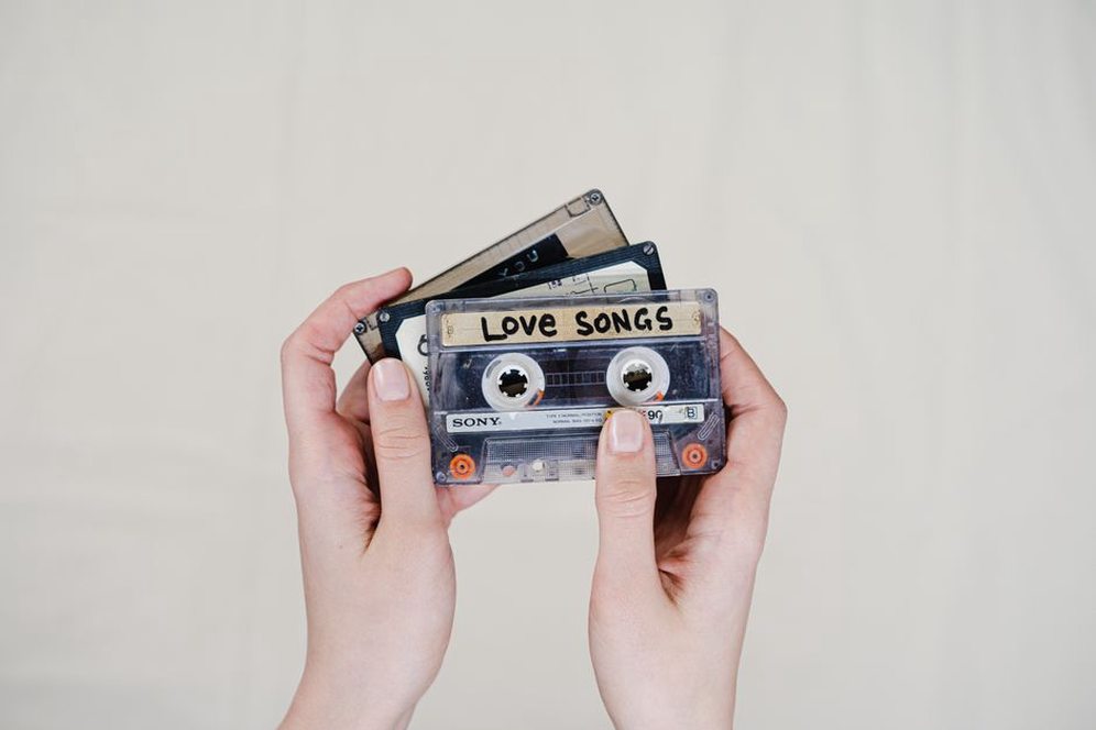 hand holding a cassette tape with handwritten label