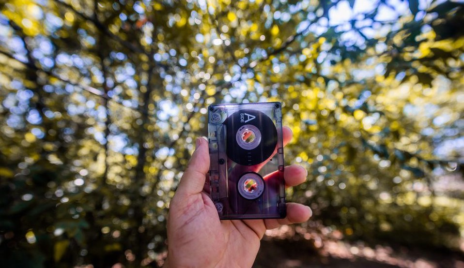 fingers gripping a handheld tape machine in a natural setting