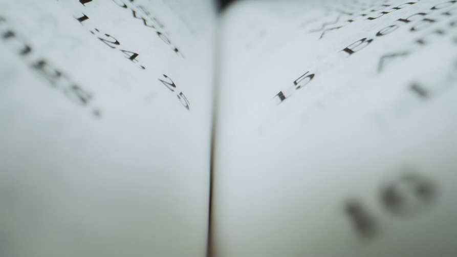 Detail of the staple binding and handwritten price adjustments on a Tesco catalogue page