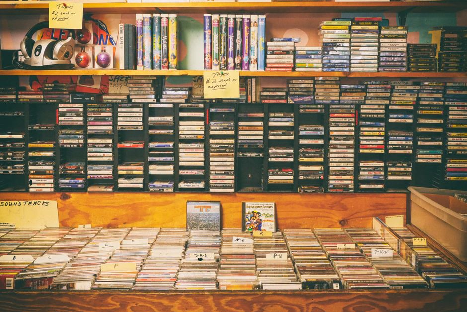 row of unlabeled cassette tapes on a shelf in a dim room