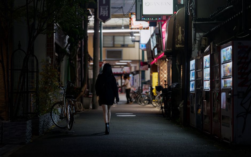 narrow Tokyo backstreet glowing under fluorescent light and tangled cables
