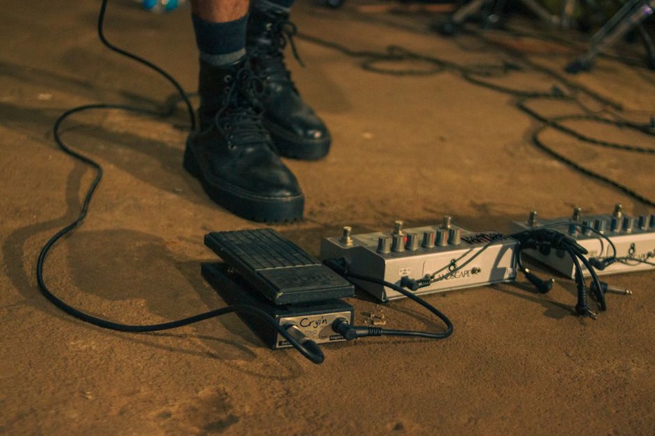 performer arranging pedals and laptop on a small table before a show