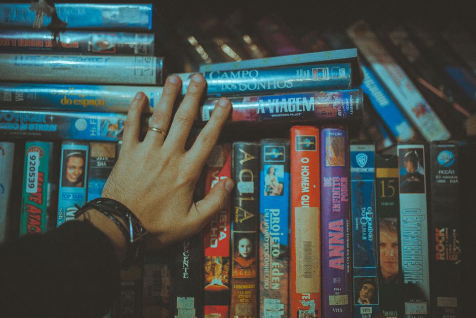 Collector sorting cassettes by handwritten codes on a shelf