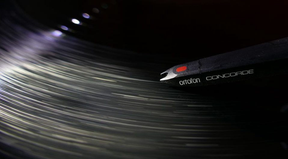 Black vinyl 7-inch record on a turntable, white label with hand-stamped text