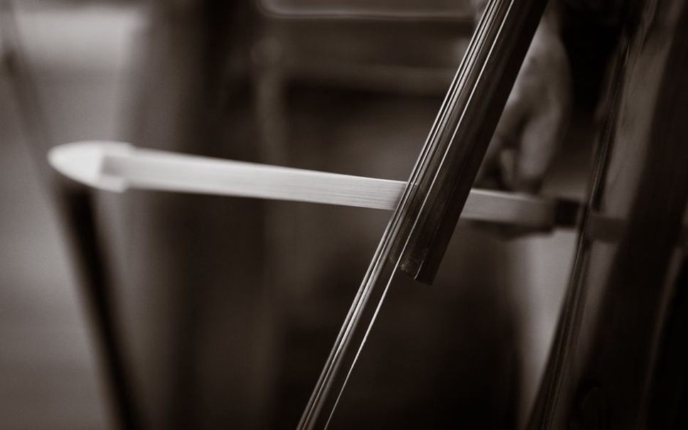 Bowed strings sustain a wavering tone onstage