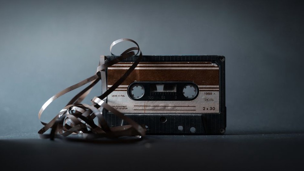 A worn cassette loop threaded through a recorder