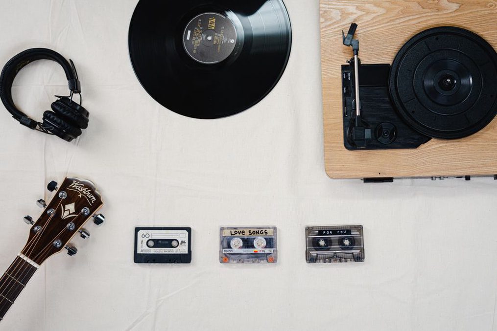 Hand-labeled tapes beside a laptop and headphones
