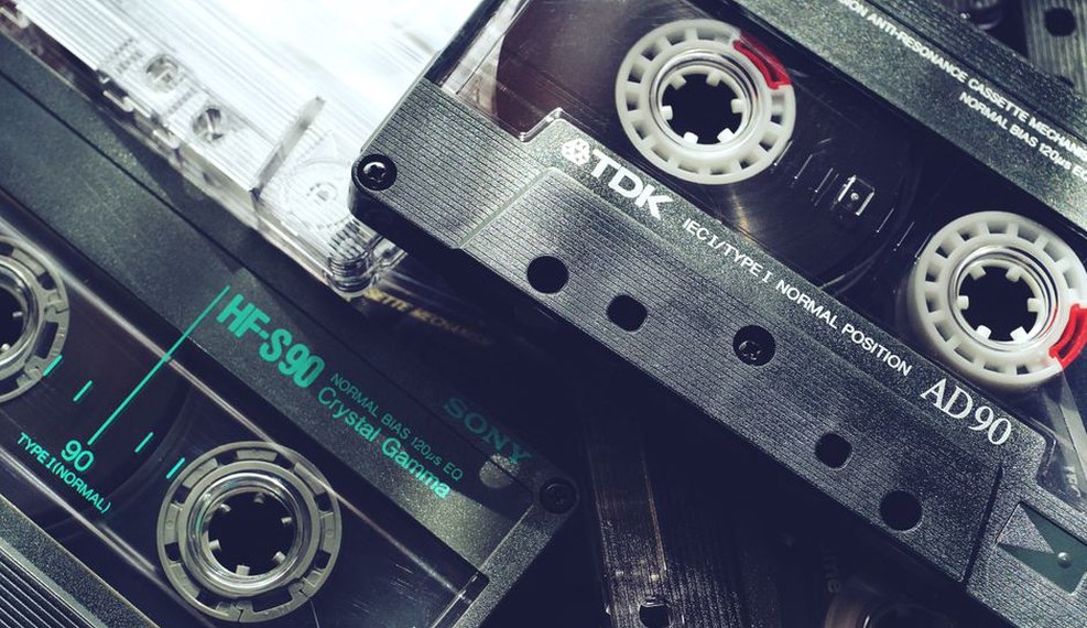 A cassette tape in motion inside a vintage tape deck, reels turning