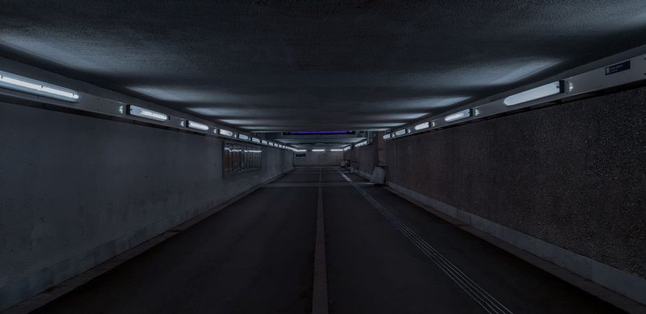 long concrete corridor with fluorescent tubes and no people
