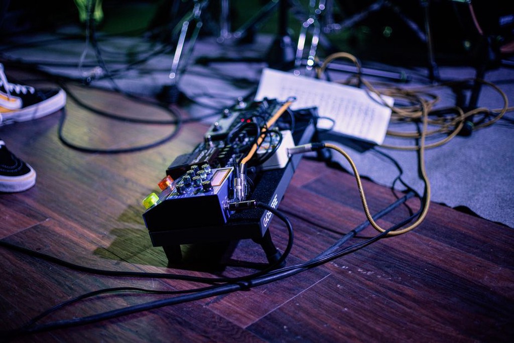 Hands adjusting a mixer during an intimate sound performance