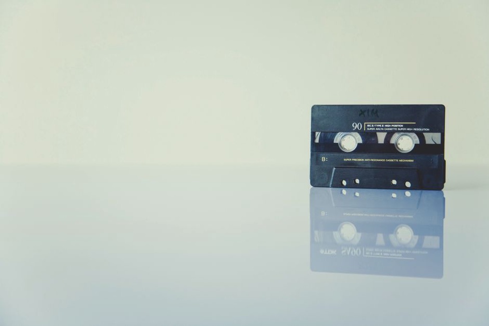 Hand-cut cassette inserts beside labeled tape shells