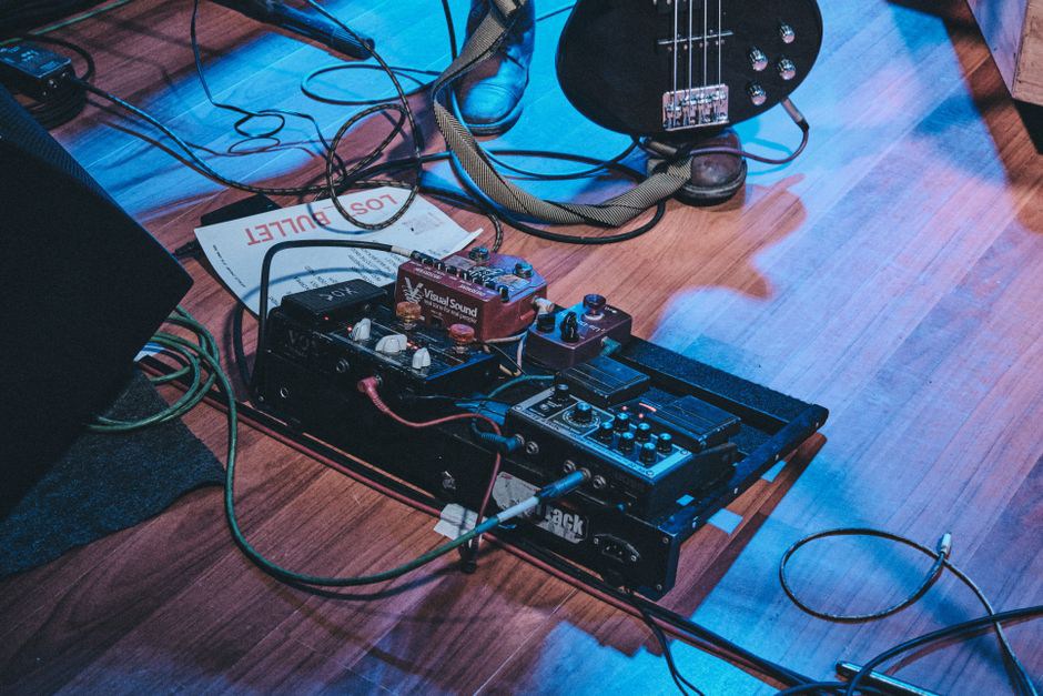 A small handmade instrument amid cables and controls