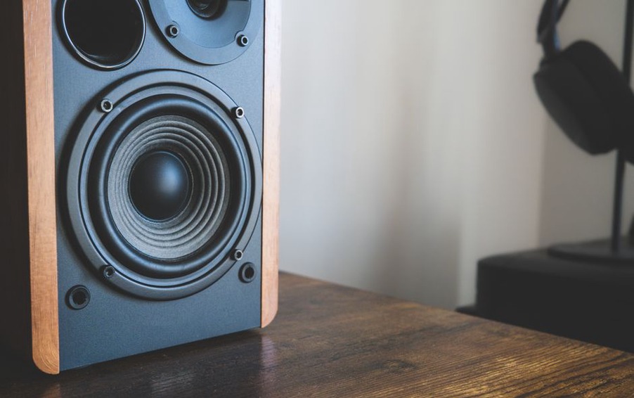 Headphones beside speakers in a quiet room