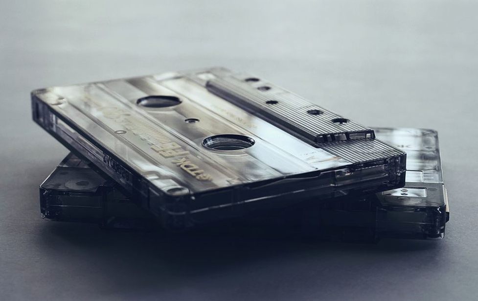 Hundreds of cassette tapes organized in plastic storage boxes inside a closet