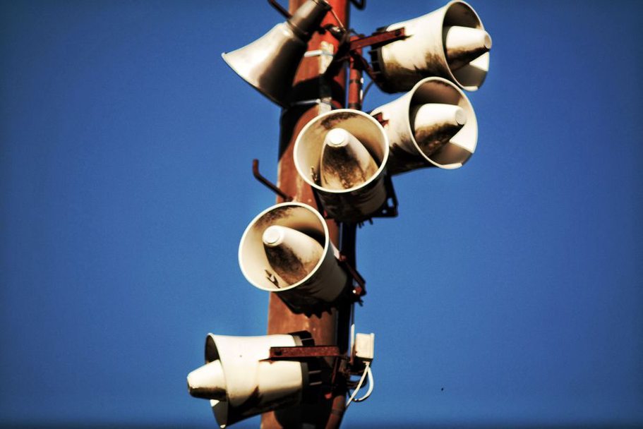 Speakers arranged across a dim gallery space