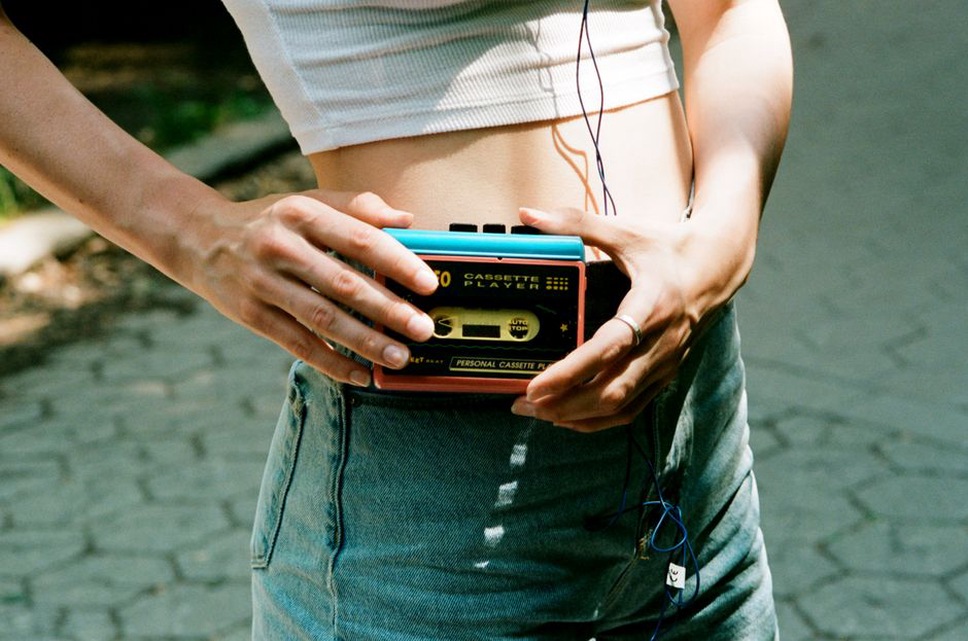 A handheld recorder beside a rain-darkened street