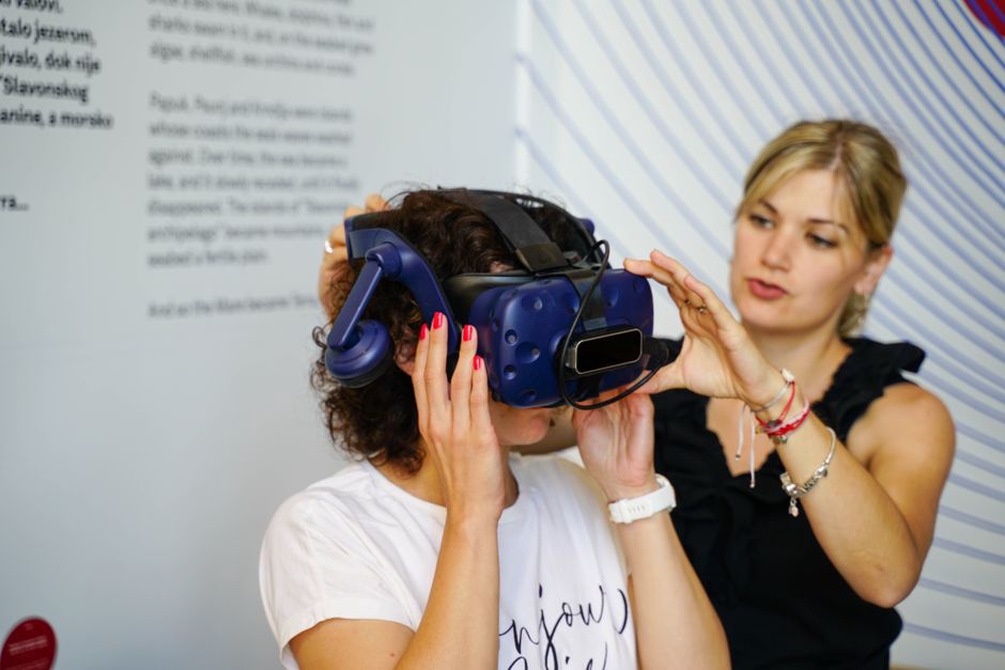 A headset wearer listens inside a gallery installation