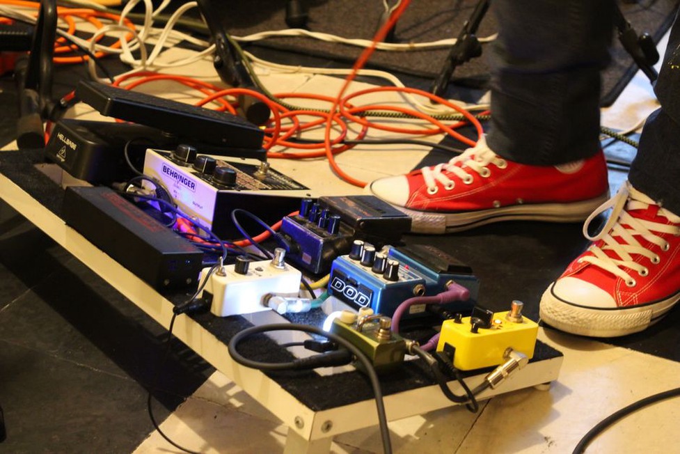 Hands adjusting pedals during a loud performance