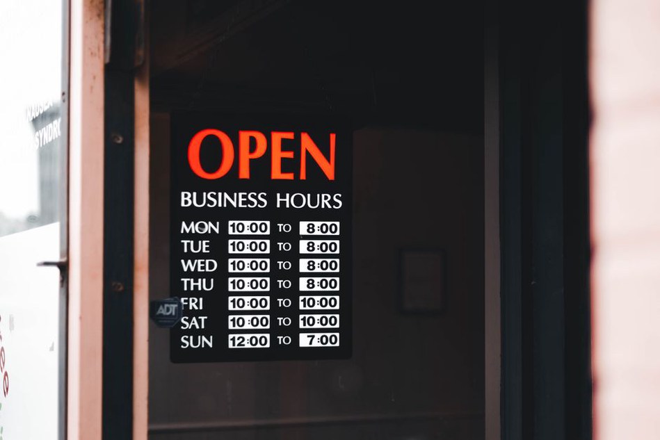 Opening hours posted beside a small shop entrance