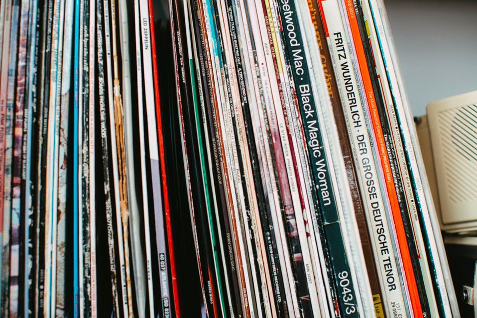 Records stored upright beside handwritten edition notes